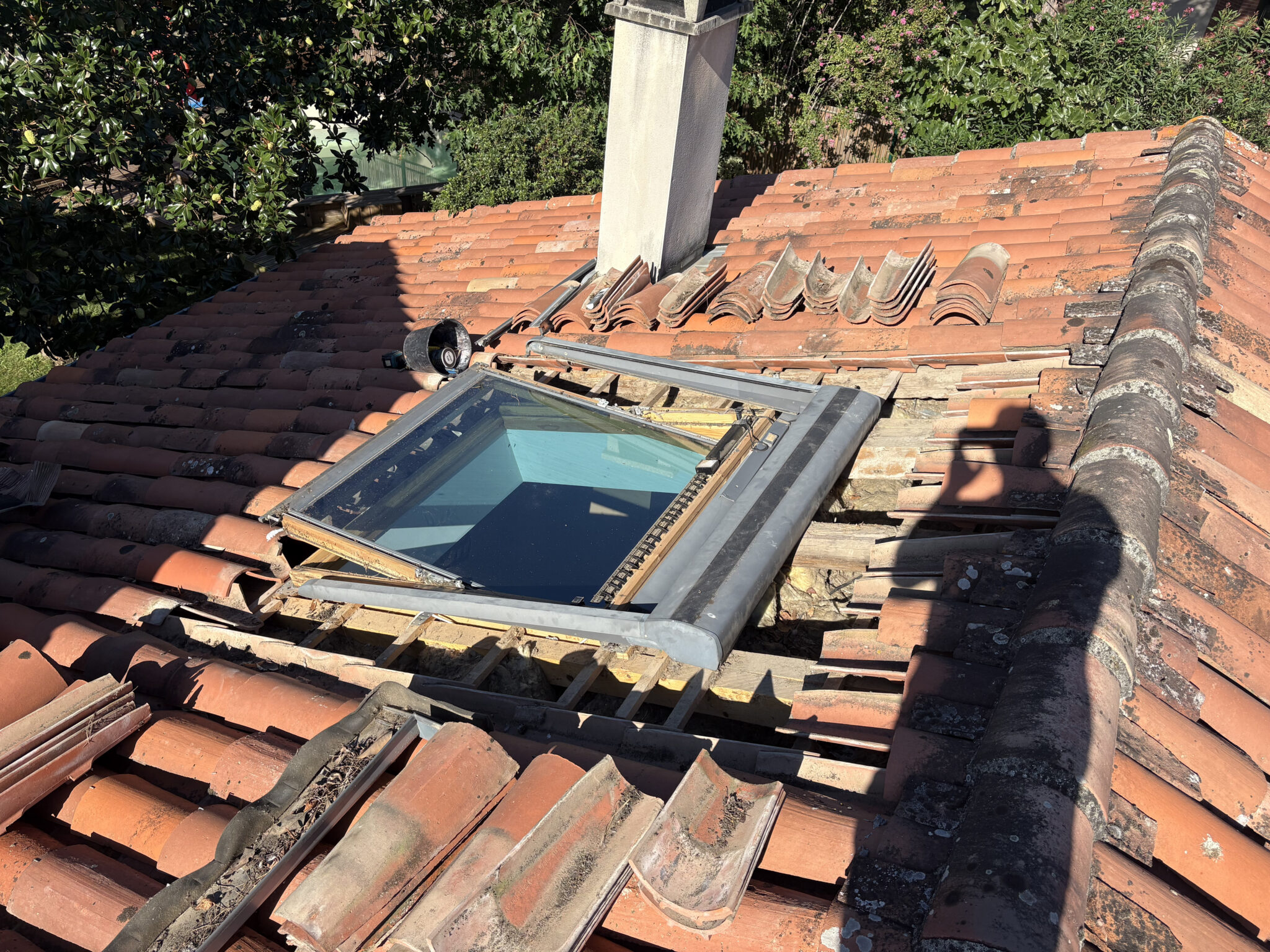 Couvreur Toulouse r&eacute;novant l&rsquo;entourage d&rsquo;un Velux en zinc sur une toiture en tuiles canal